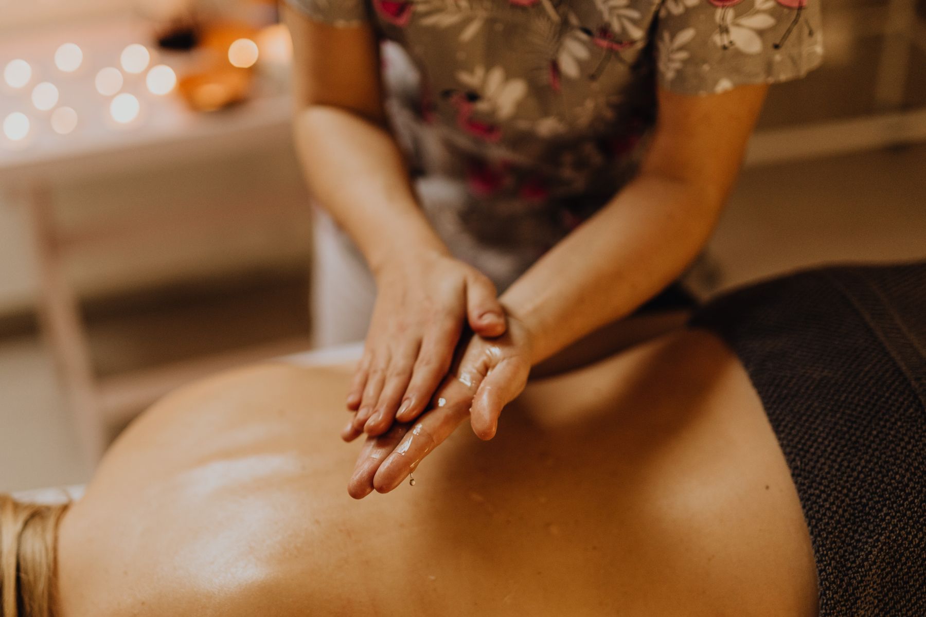 Editorial photograph of oil and attentive hands during body care